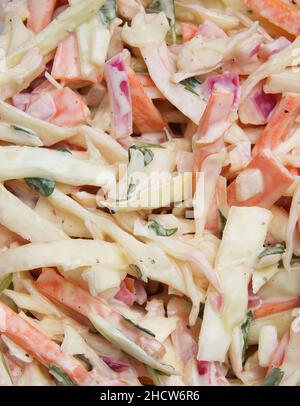 Gros plan plein cadre de chou Cole isolé fait de chou blanc cru, d'oignons rouges, de carottes, de persil vert et de sauce mayonnaise Banque D'Images