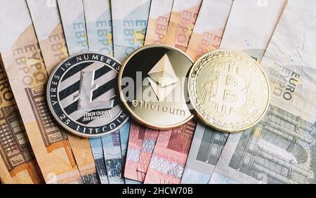 Pièces de crypto-monnaie - Litecoin, Bitcoin, Ethereum en plus des billets en euros Banque D'Images