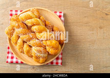 beignet de sucre en forme de spirale sur plaque en bois Banque D'Images