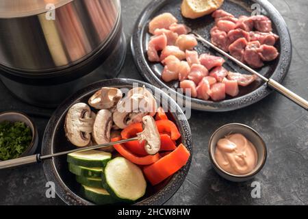 Fondue aux légumes et à la viande, à frire sur de longues fourchettes dans une casserole à l'huile chaude, repas convivial souvent servi à une fête de la Saint-Sylvestre, focau sélectionné Banque D'Images