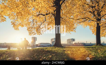 Le couple est assis sur un banc au bord du rhin à cologne à l'automne Banque D'Images