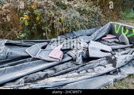 Ambleteuse, France - 22 décembre 2021 : bateau gonflable et gilet de sauvetage abandonnés par les migrants souhaitant traverser la Manche. Banque D'Images