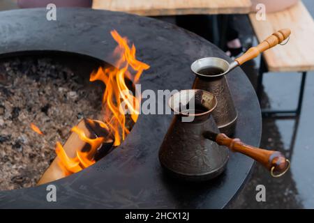 Préparation du café turc avec du cezve noir ou de l'ibrik lors du festival de la cuisine de rue Banque D'Images