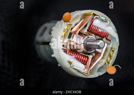 Gros plan du rotor dans le moteur électrique CC sur fond noir avec détails abstraits.Moteur électrique à l'intérieur avec contacts à balais de carbone sur le collecteur de cuivre. Banque D'Images