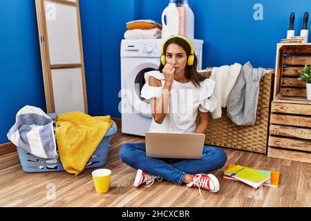 Jeune femme hispanique étudiant en attendant la lessive regardant stressé et nerveux avec les mains sur la bouche piquant les ongles. Problème d'anxiété. Banque D'Images