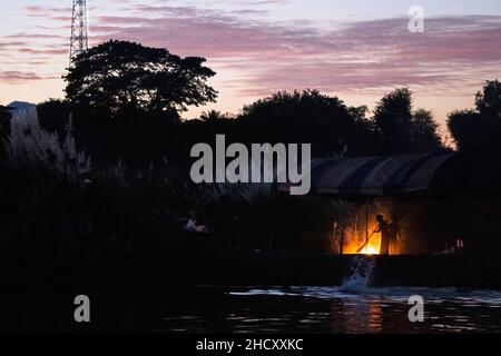 District de Mae SOT, Thaïlande.01st janvier 2022.Silhouette d'un homme Karen balayant le camping temporaire.Les Karen évacuées vivent dans un camping temporaire le long de la rivière Moei, du côté du Myanmar, qui peut être vu du côté de la Thaïlande autour du district de Mae SOT.Ils vivent ici depuis environ 3 semaines après le conflit entre l'armée du Myanmar et l'armée KNU (Union nationale Karen) dans l'État Karen du Myanmar.(Photo de Phobthum Yingpaiboonsuk/SOPA I/Sipa USA) crédit: SIPA USA/Alay Live News Banque D'Images