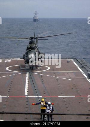 République de Singapour Force aérienne Eurocopter AS332 Super Puma décollage de la résolution RSS avec l'USS Russell à l'horizon - 20040607. Banque D'Images