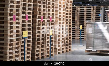 Entrepôt avec étagères et étagères, remplies de boîtes en carton, enveloppées dans du papier d'aluminium sur des palettes en bois.Attache.Grand et léger entrepôt, stockage de la cargaison dans le wo Banque D'Images