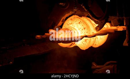 Gros plan de détail en acier chaud rouge à l'usine d'acier, concept de métallurgie lourde.Le processus de production de pièces métalliques dans un four à l'atelier chaud. Banque D'Images