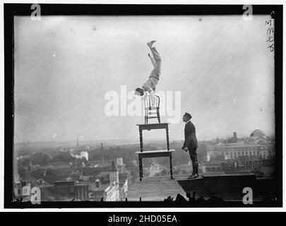 REYNOLDS, J., L'EXÉCUTION DE NUMÉROS D'ÉQUILIBRE ET ACROBATIQUE SUR LA HAUTE CORNICHE AU-DESSUS DE 9TH Street, N.W. Banque D'Images