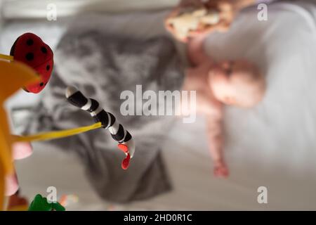 Le bébé caucasien est seul dans son berceau, couvert d'une couverture. Banque D'Images