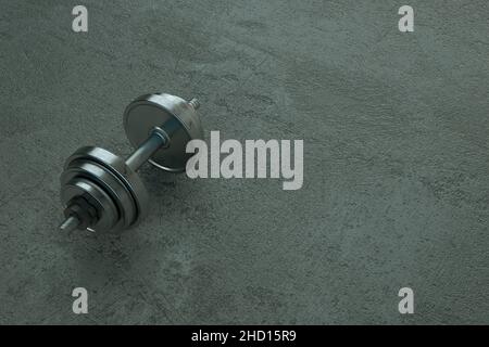 3D illustration d'une haltère métallique réaliste reposant sur un sol gris.Haltères d'objets, cloches sur fond gris isolé.Bavoir métallique gris en acier Banque D'Images