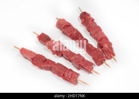 Quatre brochettes de veau et de bœuf sur fond blanc Banque D'Images