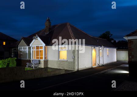 Bungalow sur une rue dans le Lancashire Angleterre éclairé avec des lumières au crépuscule Banque D'Images