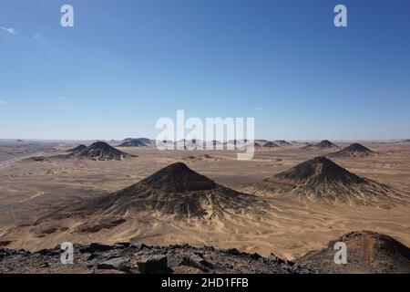 Découvrez les collines noires du dessert noir lors d'une excursion dans le désert noir et blanc, en Égypte Banque D'Images