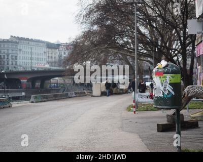 Une poubelle avec des autocollants sur un sentier de la ville. Banque D'Images