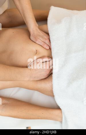 Un thérapeute massant l'abdomen de la femme post-partum. Traitement abdominal Banque D'Images