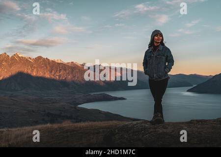 Photo verticale d'une fille hispanique debout sur l'herbe et s'appréciant en Nouvelle-Zélande Banque D'Images