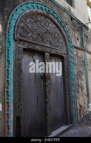 Gros plan sur une porte en bois ornée de motifs traditionnels à Lamu, Kenya Banque D'Images