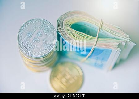Rouler les billets israéliens Shekel ils près des jetons crypto-monnaies Ethereum eth, vu d'en haut, sur fond blanc.Mise au point sélective. Avec espace pour le placement du texte.Isolé .Photo de haute qualité Banque D'Images