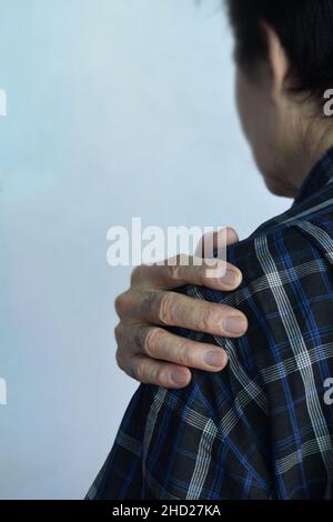 Douleur dans l'articulation de l'épaule de l'homme aîné d'Asie du Sud-est.Concept de l'épaule gelée. Banque D'Images