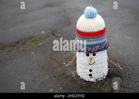 Décorations de bonhommes de neige tricotées sur des bollards à Pentyrch, au sud du pays de Galles. Banque D'Images