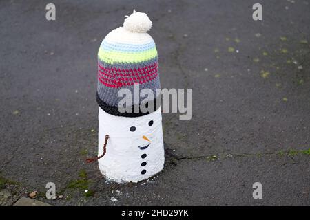 Décorations de bonhommes de neige tricotées sur des bollards à Pentyrch, au sud du pays de Galles. Banque D'Images