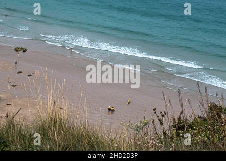 Plemont Bay, Bailiwick de Jersey - 20 juillet 2016 : deux sauveteurs assis sur des chaises dans l'eau en service supervisant plusieurs baigneurs et nageurs dans le Banque D'Images