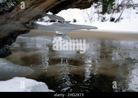 Pointe de glace formée sur une rivière couverte de glace à proximité Banque D'Images