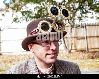 Steampunk Fashion - un homme avec une sélection de lunettes de verre multi-lensed oculaire dans des lunettes de laiton intégrées dans un chapeau de bowling Banque D'Images