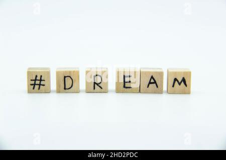 Mot Dream écrit sur les cubes de bois sur fond blanc.La photo de concept avec les lettres #Dream Banque D'Images