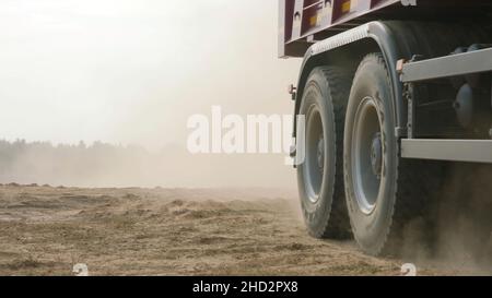 Le camion roule sur une route de carrière de sable.Scène.Vue de dessus de la conduite d'un camion-benne sur une route jaune en terre dans la campagne.Gros camions sur des chantiers de construction ou de carrière Banque D'Images