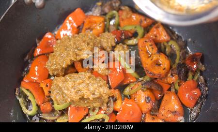 Cuisson des légumes au wok.Attache.Chef friture de l'oignon blanc haché.Hachée dans une poêle.Cuisson à la vapeur à partir de la poêle avec l'oignon.Légumes Banque D'Images