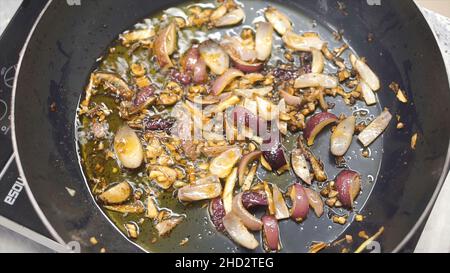 Cuisson des légumes au wok.Attache.Chef friture de l'oignon blanc haché.Hachée dans une poêle.Cuisson à la vapeur à partir de la poêle avec l'oignon.Légumes Banque D'Images