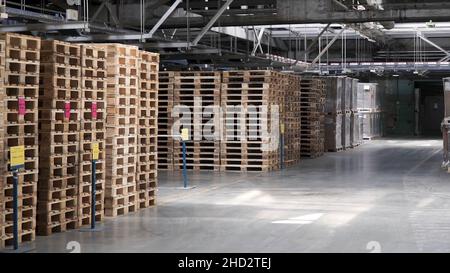 Entrepôt avec étagères et étagères, remplies de boîtes en carton, enveloppées dans du papier d'aluminium sur des palettes en bois.Attache.Grand et léger entrepôt, stockage de la cargaison dans le wo Banque D'Images