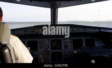 Vue arrière des commandes de pilotage du jet d'entreprise.Capitaine dans le cockpit de l'avion, se préparant au départ du vol.Se concentrer sur son pilote eulet Banque D'Images