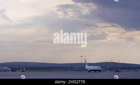 Employés d'aéroport qui manipulent un avion.Avion stationné à l'aéroport et préparation pour le prochain vol.Gros plan haute vue sur les passagers blancs modernes Banque D'Images