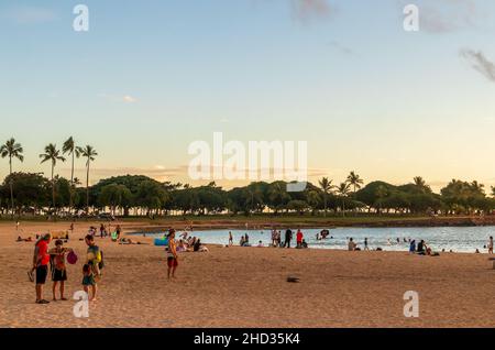 Honolulu, Hawaï - 2 décembre 2021 : coucher de soleil sur l'océan depuis la plage d'Ala Moana et le parc régional.Les gens apprécient la chaude soirée Banque D'Images