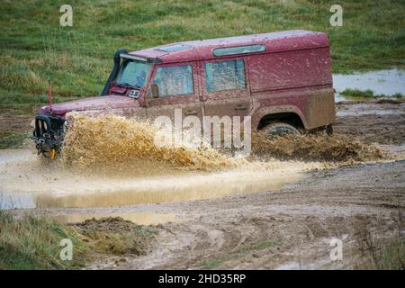 Un véhicule Land Rover 110 LWB conduit hors route à travers les eaux profondes et boueuses de Salisbury Plain Royaume-Uni Banque D'Images