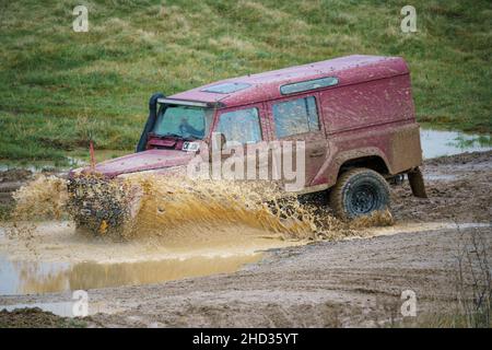 Un véhicule Land Rover 110 LWB conduit hors route à travers les eaux profondes et boueuses de Salisbury Plain Royaume-Uni Banque D'Images