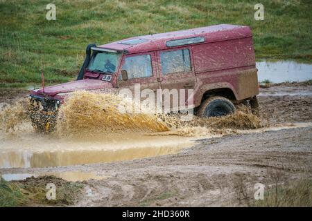 Un véhicule Land Rover 110 LWB conduit hors route à travers les eaux profondes et boueuses de Salisbury Plain Royaume-Uni Banque D'Images