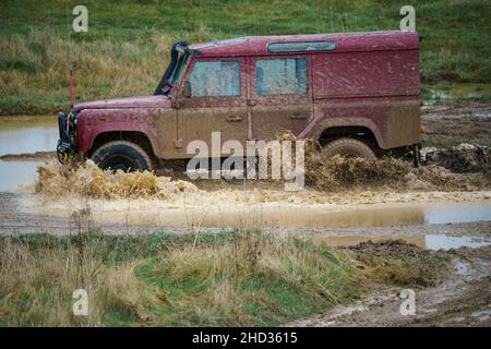 Un véhicule Land Rover 110 LWB conduit hors route à travers les eaux profondes et boueuses de Salisbury Plain Royaume-Uni Banque D'Images