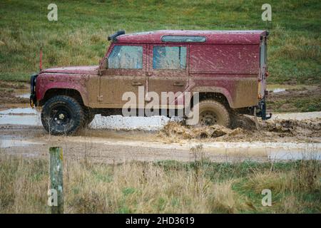 Un véhicule Land Rover 110 LWB conduit hors route à travers les eaux profondes et boueuses de Salisbury Plain Royaume-Uni Banque D'Images