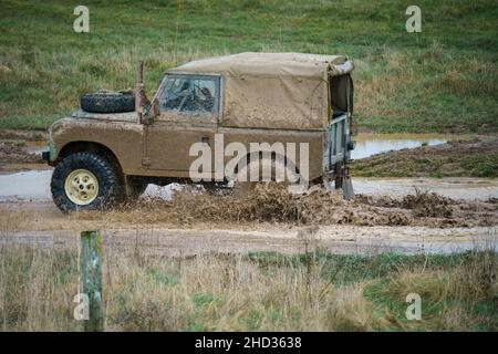 Un véhicule Land Rover conduit hors route à travers les eaux profondes et boueuses de Salisbury Plain Royaume-Uni Banque D'Images