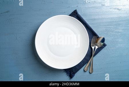 Vue de dessus d'une assiette avec une fourchette et une cuillère sur une table en bois bleu Banque D'Images