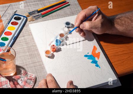 Peinture des mains avec aquarelles sur une toile Banque D'Images