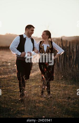 Photo verticale d'un jeune couple multiracial dansant dans un costume traditionnel serbe en Serbie Banque D'Images