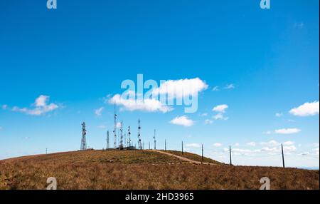 Ciel bleu et colline avec antennes de télécommunication. Banque D'Images