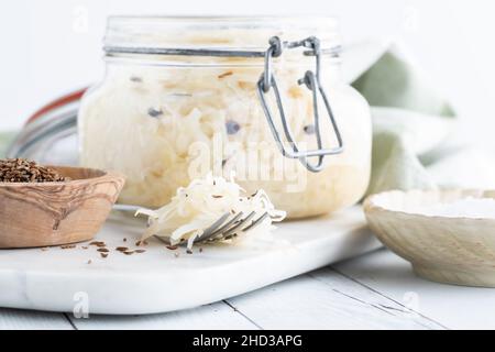 Gros plan d'un pot de choucroute fraîche avec une fourchette pleine devant. Banque D'Images