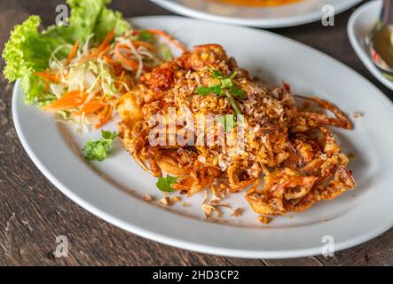 Gros plan sur l'image de la cuisine thaïlandaise, crabe en coquille douce frite à l'ail sur une table en bois, crabe en coquille douce frite à l'ail.angle de vue de 45 degrés. Banque D'Images